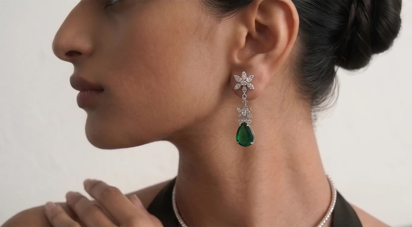 Close profile of the model's emerald drop earring